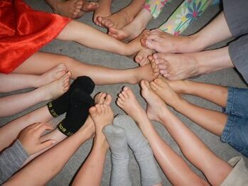children in circle touching feet